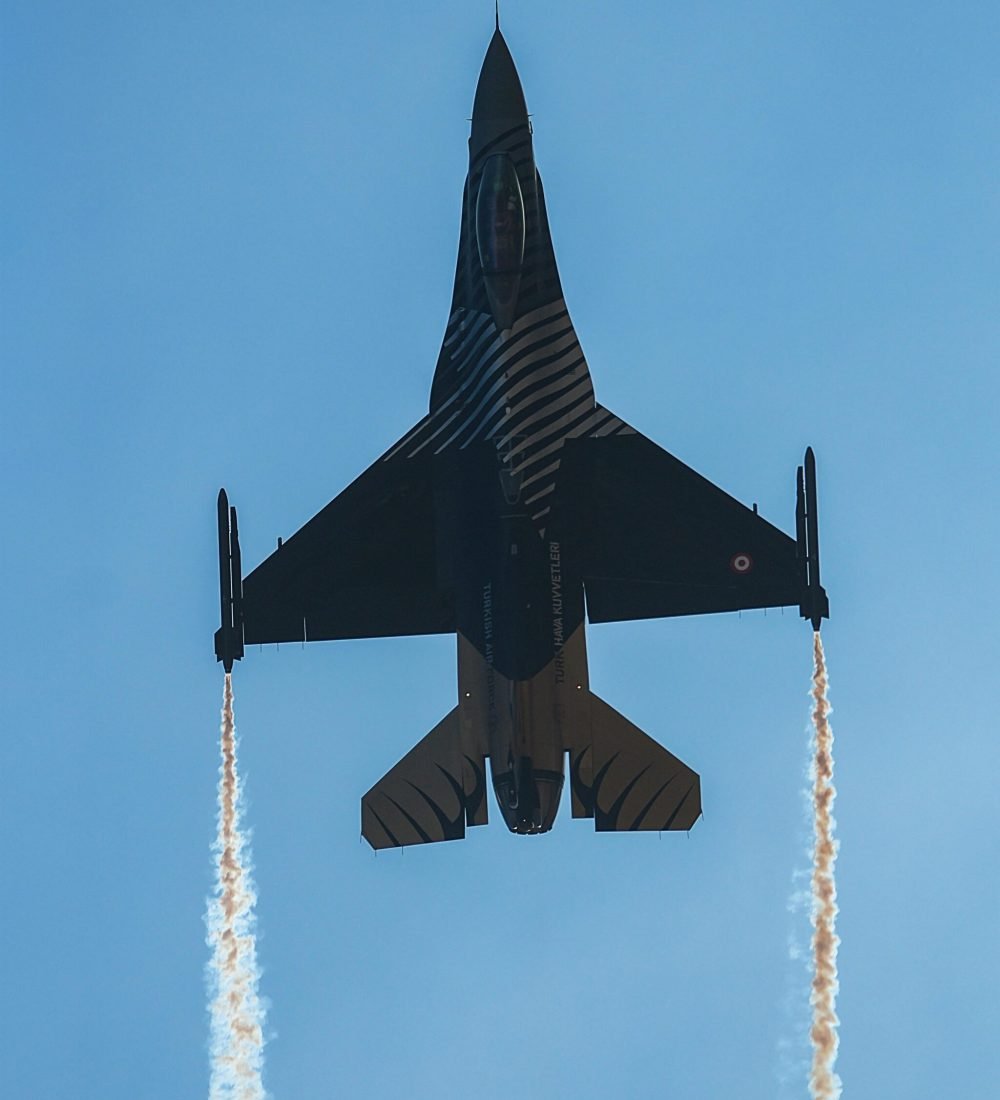 pexels-photo-34757234-34757234 A jet aircraft performing an impressive aerial maneuver, leaving contrails against a clear blue sky.